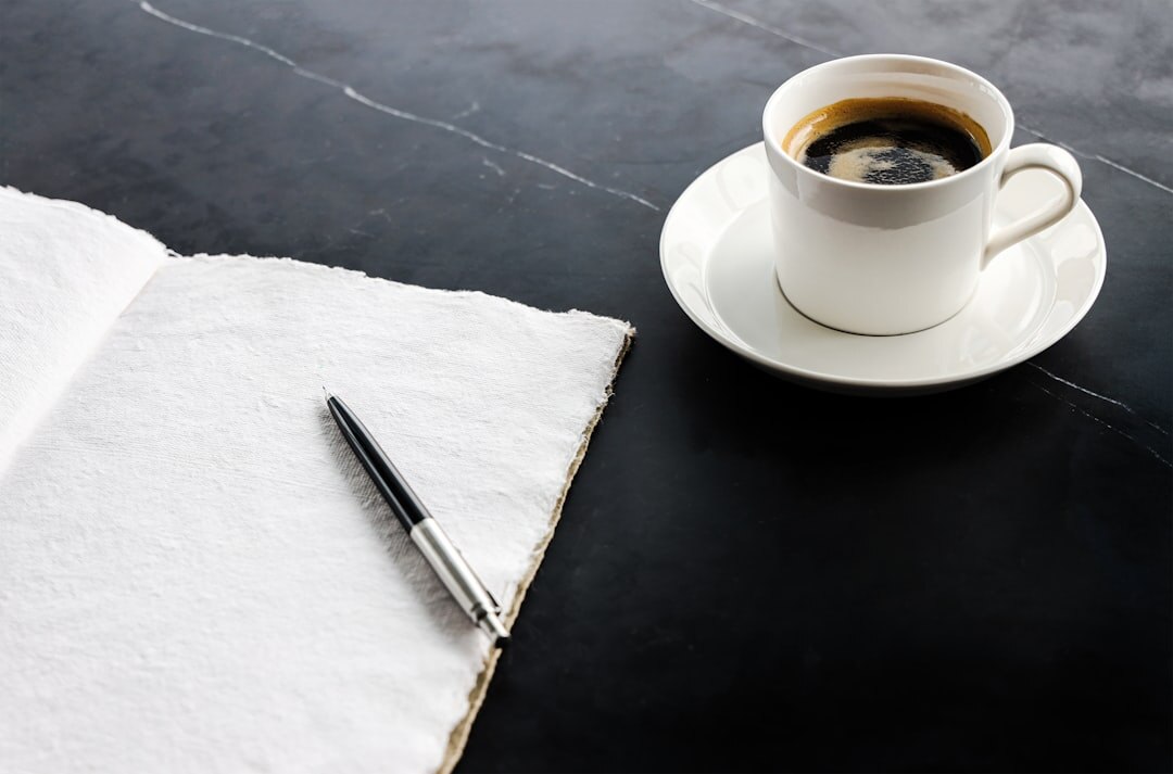 Close-up of manuscript pages with a fountain pen and cup of coffee